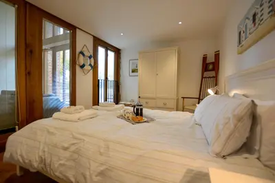 a bedroom with a large bed with towels on it at Two Chantry Barns, Orford in Orford