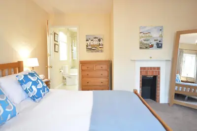 a bedroom with a large bed and a fireplace at Gosfield Cottage, Aldeburgh in Aldeburgh