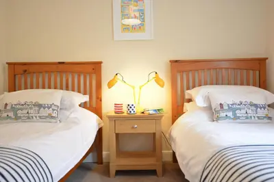 two beds sitting next to each other in a bedroom at Gosfield Cottage, Aldeburgh in Aldeburgh