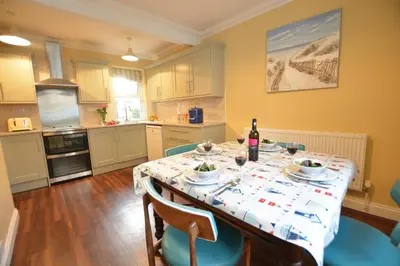 a kitchen with a table with a table cloth on it at Gosfield Cottage, Aldeburgh in Aldeburgh