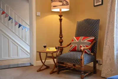 a room with a chair and a table with a lamp at Gosfield Cottage, Aldeburgh in Aldeburgh
