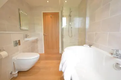 a bathroom with a toilet a sink and a shower at Manor House Barn, Peasenhall in Peasenhall