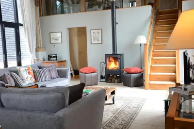 a living room with a couch and a fire place at Manor House Barn, Peasenhall in Peasenhall