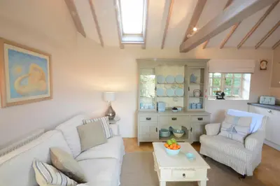 a living room with a white couch and a table at The Nookery at Snape Hall in Snape