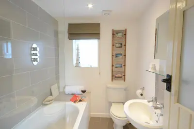 a bathroom with a tub and a toilet and a sink at The Nookery at Snape Hall in Snape