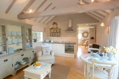 a kitchen and living room with a table and chairs at The Nookery at Snape Hall in Snape
