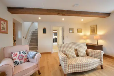 a living room with two chairs and a couch at Woodland Cottage, Great Glemham in Framlingham