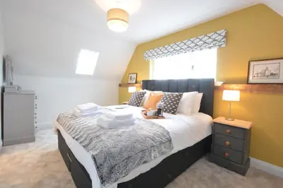 a bedroom with a large bed and a window at Woodland Cottage, Great Glemham in Framlingham