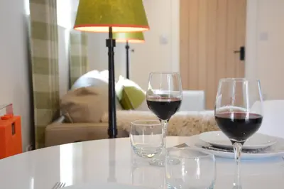 two glasses of red wine sitting on a table at Carriage House, Bruisyard in Framlingham