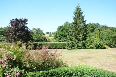 a garden with flowers and trees in a field at Carriage House, Bruisyard in Framlingham