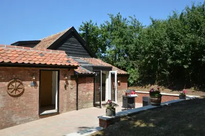 a brick house with a patio in front of it at Carriage House, Bruisyard in Framlingham