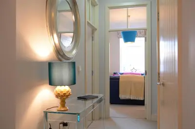 a room with a table with a lamp and a mirror at Skimming Stones, Aldeburgh in Aldeburgh