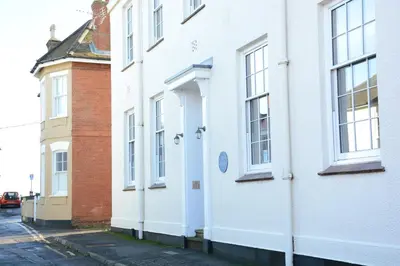 a white building with a door on a street at Skimming Stones, Aldeburgh in Aldeburgh