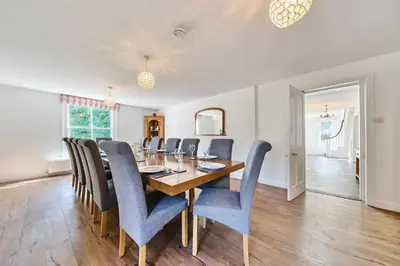 a dining room with a wooden table and blue chairs at Bedingfield House, nr Debenham in Debenham