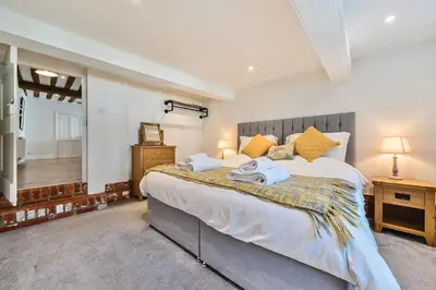 a bedroom with a large bed with towels on it at Bedingfield House, nr Debenham in Debenham