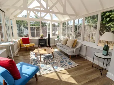 a living room with a lot of windows at The Round House in Kettleburgh