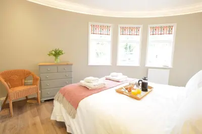 a bedroom with a bed with a tray of food on it at The Round House in Kettleburgh