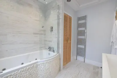 a white bathroom with a tub and a shower at 53 Tern Cottage, Aldeburgh in Aldeburgh