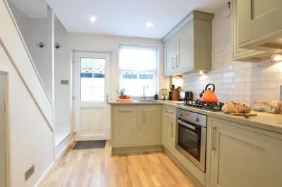 a kitchen with white cabinets and a stove top oven at 53 Tern Cottage, Aldeburgh in Aldeburgh