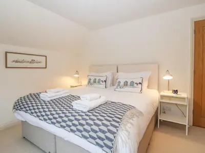 a bedroom with a large bed with towels on it at Mellows, Thorpeness in Thorpeness