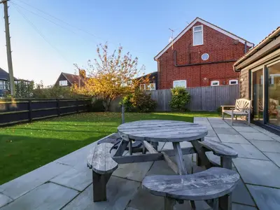 a picnic table and two chairs on a patio at Mellows, Thorpeness in Thorpeness