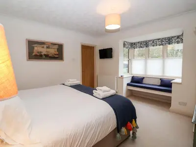 a bedroom with a large white bed and a window at Mellows, Thorpeness in Thorpeness