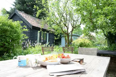 a wooden table with a bowl of fruit on it at The White House with Studio in Homersfield