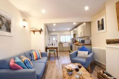 a living room with a blue couch and a table at Smugglers Rest, Aldeburgh in Aldeburgh