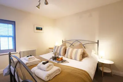 a bedroom with a bed with towels on it at Smugglers Rest, Aldeburgh in Aldeburgh