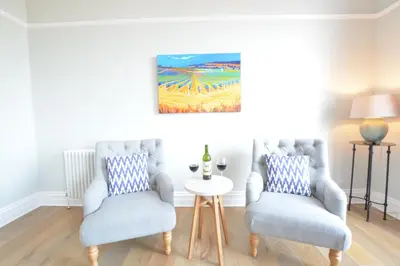 a living room with two chairs and a table at Wide Skies, Aldeburgh in Aldeburgh