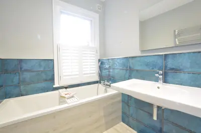 a bathroom with a sink and a tub and a window at Wide Skies, Aldeburgh in Aldeburgh