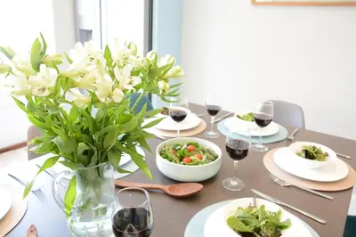 a table with plates of food and glasses of wine at Wide Skies, Aldeburgh in Aldeburgh