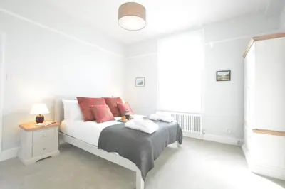 a white bedroom with a bed and a window at Wide Skies, Aldeburgh in Aldeburgh