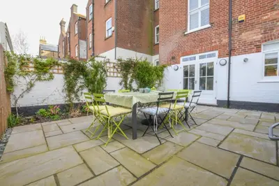 a patio with a table and chairs and a building at Wide Skies, Aldeburgh in Aldeburgh