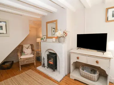 a living room with a fireplace and a flat screen tv at Rosemary Cottage, Aldeburgh in Aldeburgh