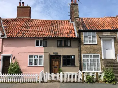 a pink house with a white fence at Rosemary Cottage, Aldeburgh in Aldeburgh