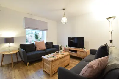 a living room with two couches and a tv at Lapwings, Aldeburgh in Aldeburgh