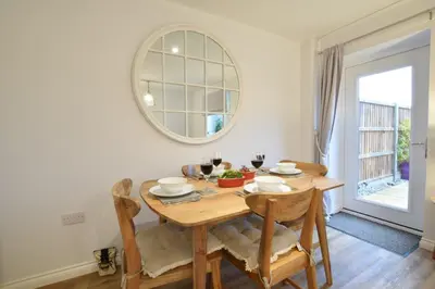 a dining room with a wooden table and a mirror at Lapwings, Aldeburgh in Aldeburgh