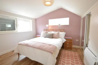a bedroom with a large bed and a window at Bramertons Nest, Long Melford in Long Melford