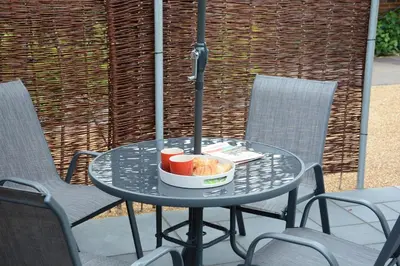 a table with a bowl of donuts and drinks on it at Bramertons Nest, Long Melford in Long Melford