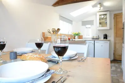 a table with glasses of wine and bread on it at The Moorings, Orford in Orford