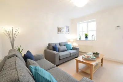 a living room with a couch and a table at Bluebelle Cottage, Peasenhall in Peasenhall