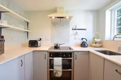a kitchen with a sink and a stove top oven at Satis Cottage, Westleton in Westleton