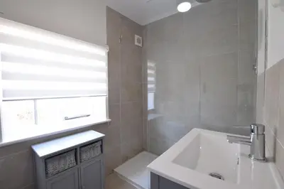 a bathroom with a sink and a window and a tub at Satis Cottage, Westleton in Westleton