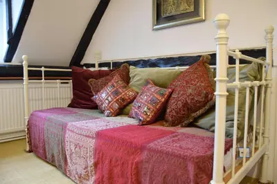 a bed with pillows on it in a room at Church Farmhouse, Cookley in Halesworth