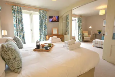 a large white bed with a tray of food on it at Tamarisk, Aldeburgh in Aldeburgh