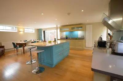 a kitchen with a blue island in the middle at Tamarisk, Aldeburgh in Aldeburgh