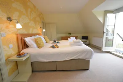 a bedroom with a large bed with white sheets at Tamarisk, Aldeburgh in Aldeburgh