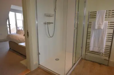 a shower with a glass door in a bathroom at Tamarisk, Aldeburgh in Aldeburgh