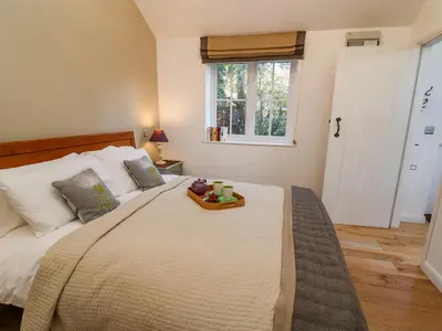 a bedroom with a large bed with a tray on it at The Bothy at Snape Hall in Snape